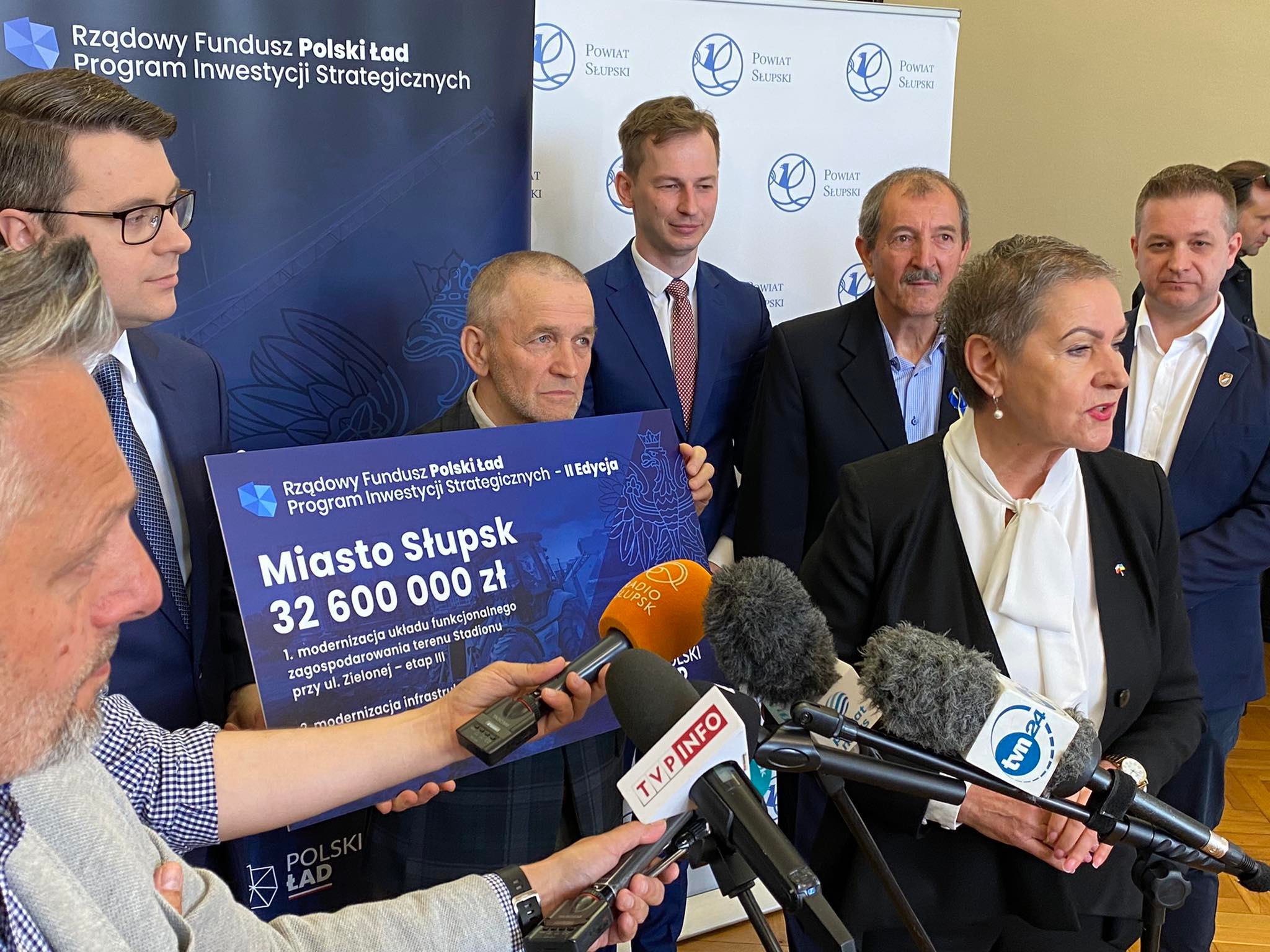 Na zdjęciu widzimy Prezydentkę Miasta, Posła na Sejm RP trzymającego tablicę z dofinansowaniem jak w treści artykułu, radnych PiSu oraz mikrofony dzienniakrskie