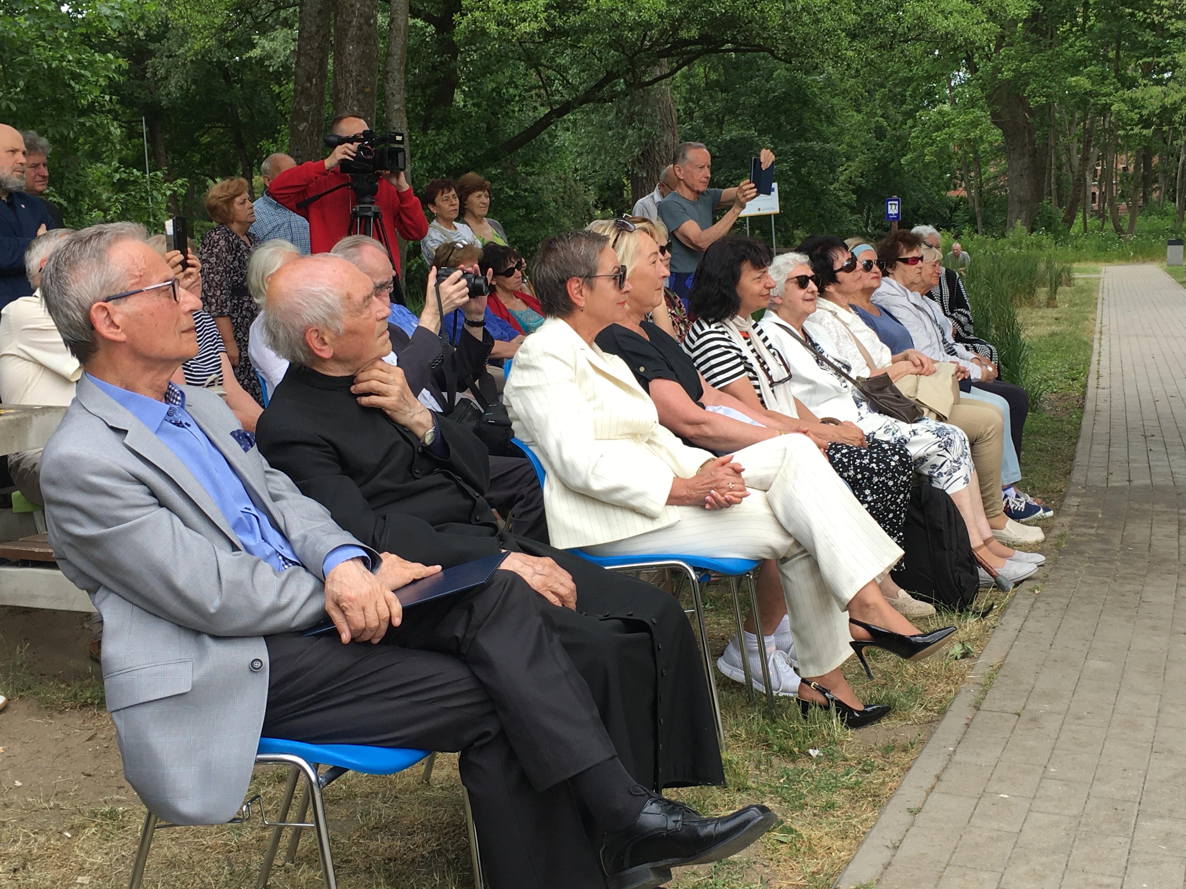 Goście uroczystości, w tym Prezydentka Miasta, siedzą na krzesłach.