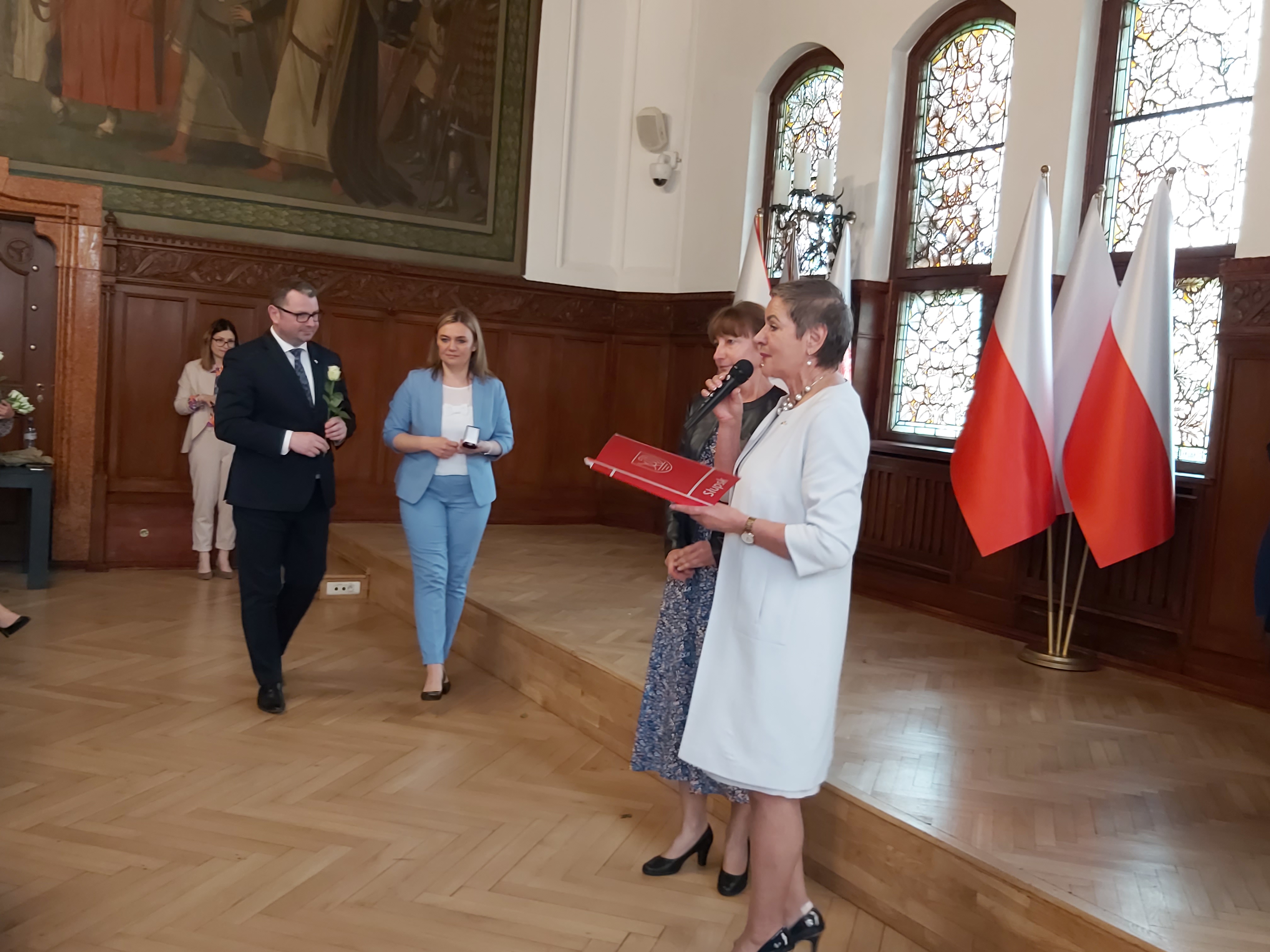 Prezydentka Miasta wręcza list urzędniczce, w tle Skarbniczka i Wiceprezydent