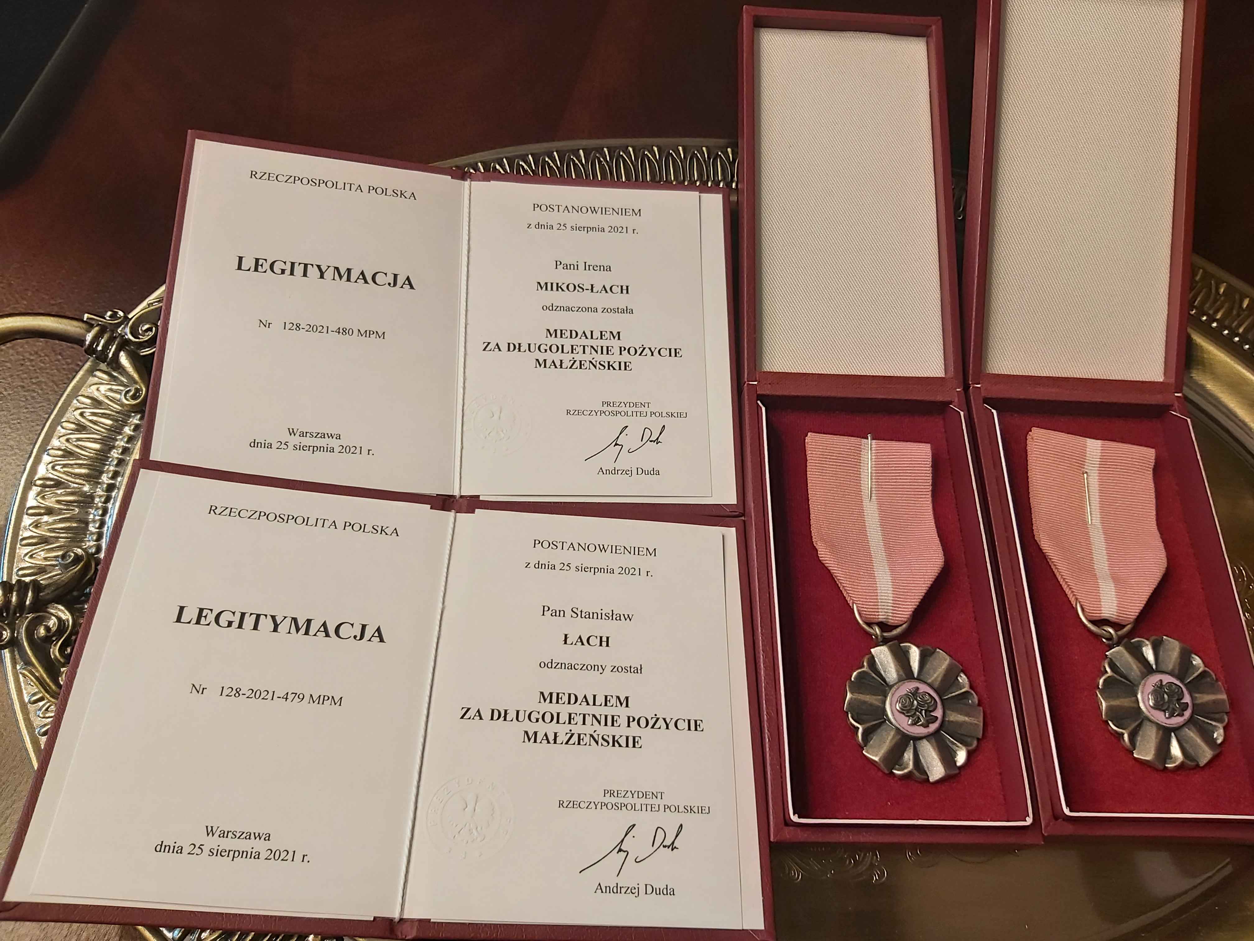 Na zdjęciu widzimy 2 okolicznościowe medale za Długoletnie Pożycie Małżeńskie oraz Legitymacje dla Pana Stanisława Łach oraz Pani Ireny  Mikos-Łach  z tej samej okazji
