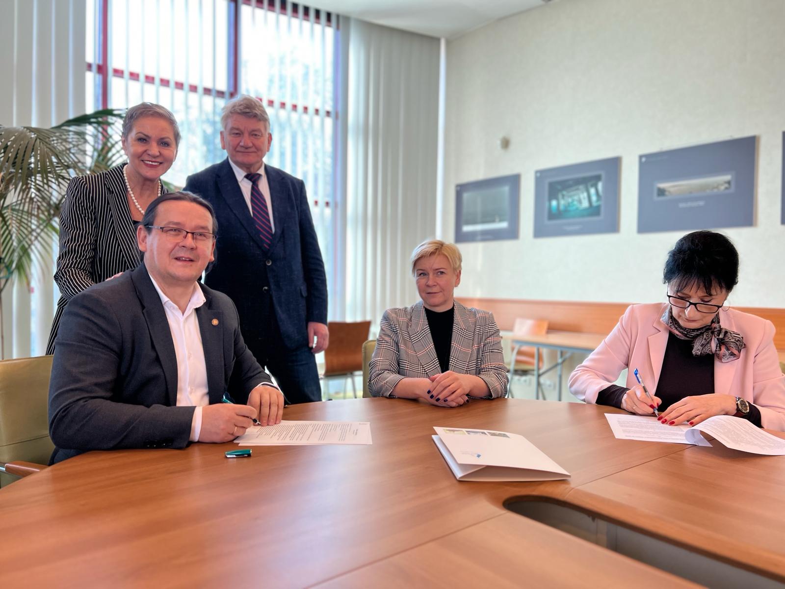 Pani Prezydent i Wójt Gminy Kobylnica oraz trzy inne osoby siedzące przy stole i podpisujące umowę, w tym Prezesi Engie i Wodociągów Słupk