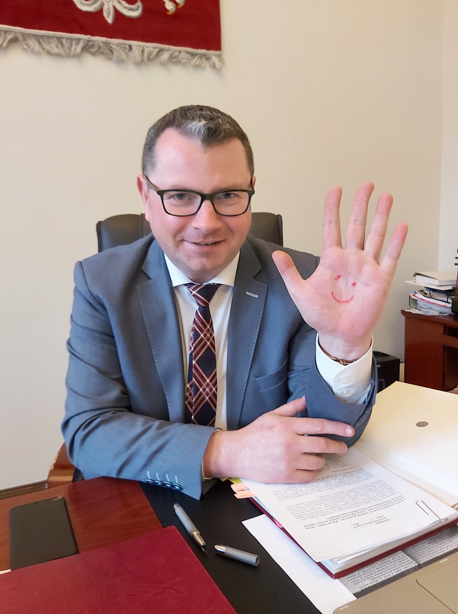 Wiceprezydent Goliński z namalowaną uśmiechniętą buźką na dłoni