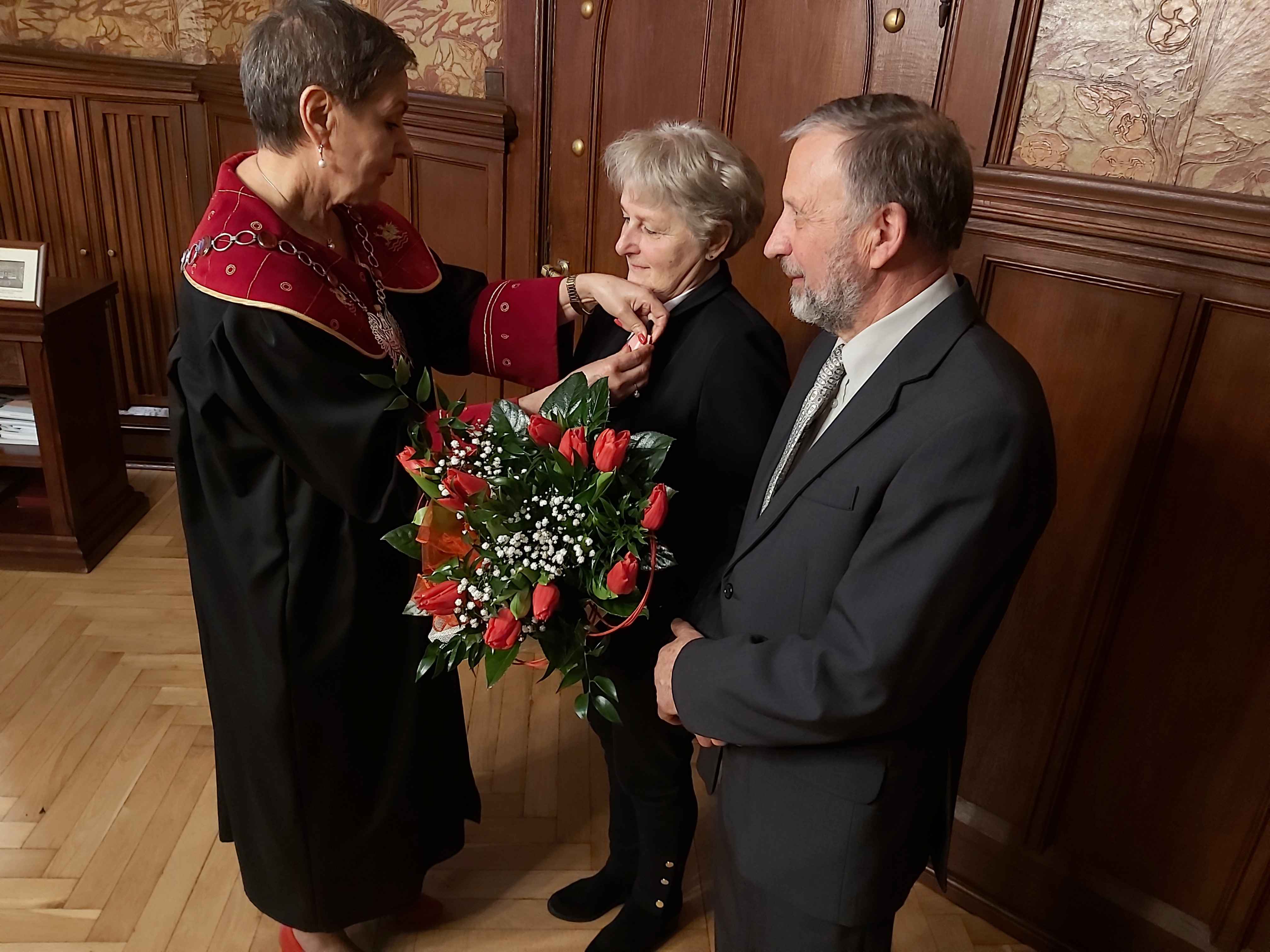 Prezydentka MIasta wpina medal w klapę marynarki Jubilatki; obok Jubilat