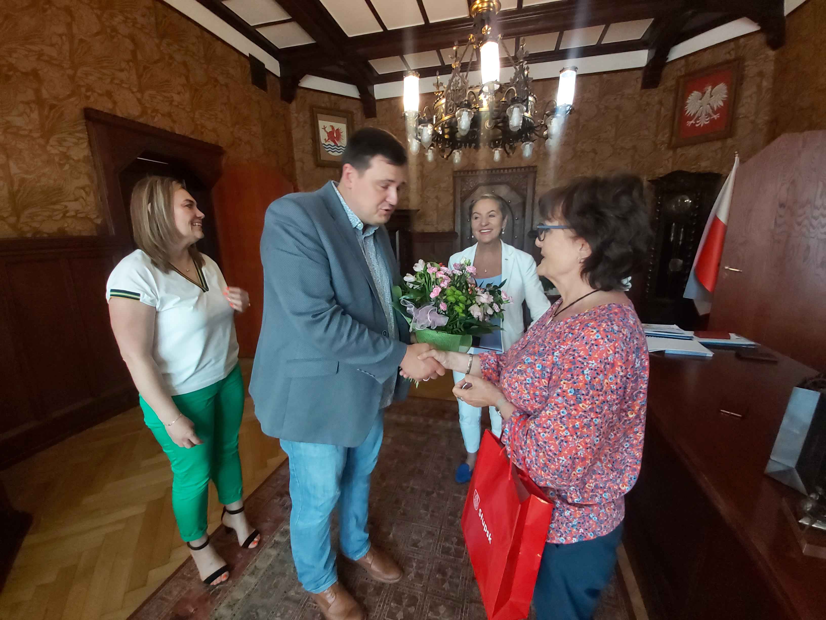 Pan Sekretarz wręcza Pani Krystynie Wrycz Kwiaty, w tle Pani Prezydent, obok Pani Skarbnik