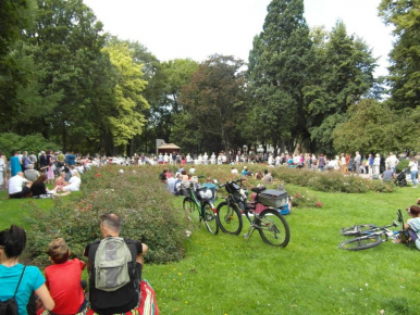 zielony park Waldorffa uczestnicy koncertu siedzą na trawie