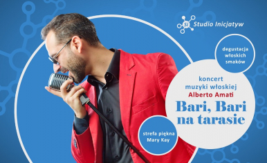 mężczyzna w czerwonej marynarce trzyma w dłoni mikrofon na statywie