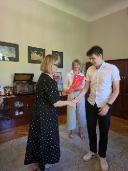Zdjęcie przedstawia moment wręczania podziękowań dla ucznia przez Panią Beatę Chrzanowską, w tle widać dyrektorka szkoły Pani Aldona Pląska.