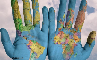 Na zdjęciu mapa świata na otwartych dłoniach