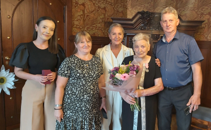 Kierownik USC, Bliscy Jubilatki, Pani Prezydent oraz Jubilatka, w tle gabinet prezydencki, szafa, krzesła; Jubilatka trzyma bukiet, a Kierownik USC Medale