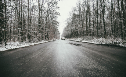 zdjęcie poglądowe drogi z gołoledź, samochód, po bokach las