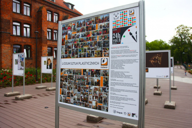 gragment wystawy plenerowej, plansza opiowa Liceum Sztuk Plastycznyh z kolażem fotografii