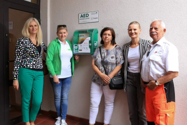 Na zdjęciu widizmy 5 osób, w tym m.in. Wiceprezydentkę Makuch; na zdjęciu są 4 kobiety i 1 mężczyzna, stoją przy ścianie, przy której zamontowany jest defibrylator AED. Fot. Biblioteka Słupska