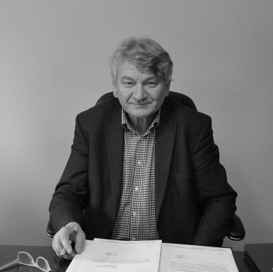 Fotografia Wójta Kulińskiego przy biurku; na blacie dokumenty, okulary; źródło: Obserwator Słupsk