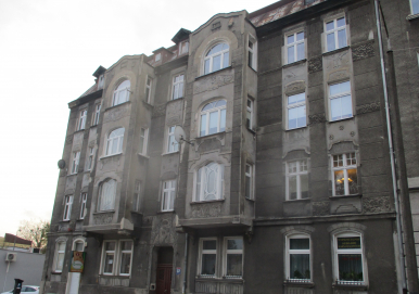 Zdjęcie przedstawia budynek, w którym znajduje się lokal mieszkalny na sprzedaż.