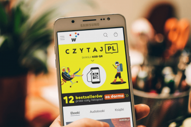 eran telefonu komórkowego, na którym widoczny jest baner akcji Czytaj.pl z napisem 12 bestsellerów za darmo przez cały listopad