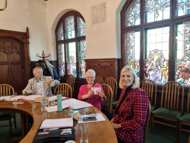 Trzy osoby w sali konferencyjnej siedzą przy okrągłym stole na posiedzeniu Słupskiej Rady Seniorów, od lewej mężczyzna i dwie kobiety.