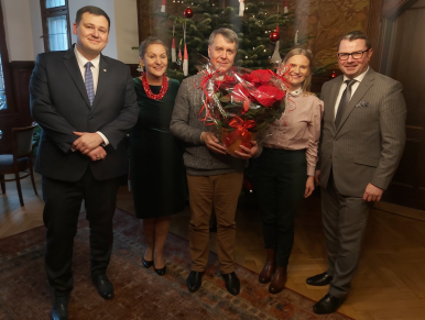 Na zdjęciu widzimy Radnego Wojciecha Gajewskiego trzymającego gwiazdę betlejemską, Prezydentów Słupska oraz Sekretarza Miasta, w tle krzesło i choinka