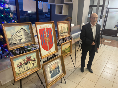 Zdjęcie poglądowe od Organizatorów - komisarza wystawy ze Stowarzyszenia Marynistów Polskich - kilka obrazów i  osoba prezentująca je na sztalugach