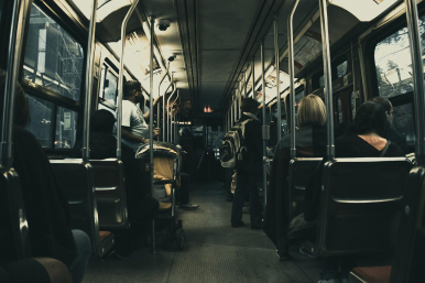 Na zdjęciu widzimy wnętrze autobusu miejskiego- siedzenia i uchwyty oraz  zafolionwany holder.