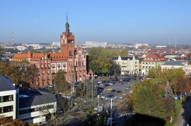 Na zdjęciu widać panoramę miasta z widokie na ratusz, pl.Zwycięstwa oraz szereg budynów
