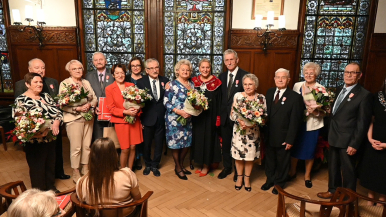 Julilaci i Prezydentka Słupska w sali ratusza, w tle lampy i witraże