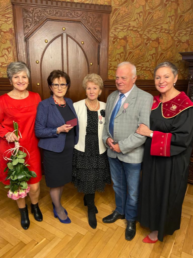 Na zdjęciu widzimy 5 osób, Jubilatów i bliską osobę, Prezydentkę Miasta oraz Kierownick Urzedu Stanu Cywilnego. Jedna z kobiet trzyma kwiaty, Jubilaci mają przypięte medale.