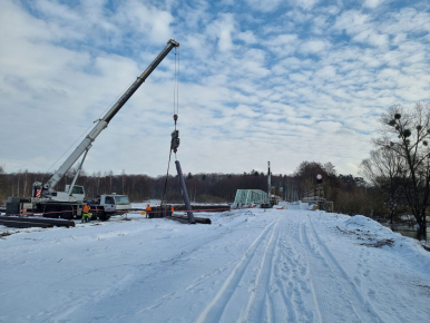 Widok na most czołgowy i sprzęt budowlany, w tle las