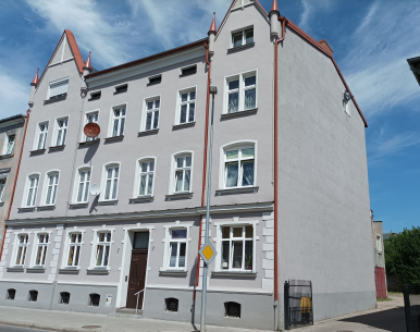 Zdjęcie przedstawia budynek, w którym znajduje się lokal mieszkalny na sprzedaż.