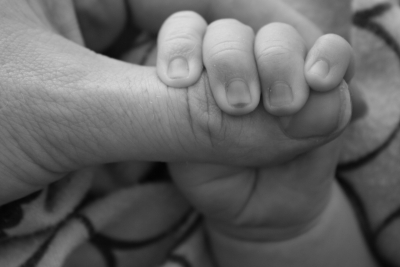 Dziecko trzyma za palec dorosłego (widok jedynie dłoni)