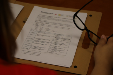 zdjęcie dokumentu, widoczna ręka trzymajaca okulary