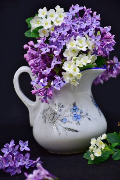 Na zdjęciu widzimy dzbanuszek z kwiatkami w środku (białe i fioletowe o małych płatkach)