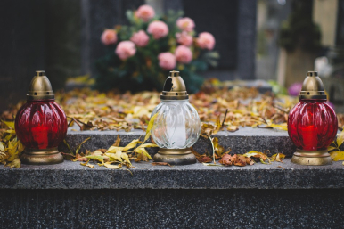 Groby zmarłych udekorowane kwiatami i zniczam