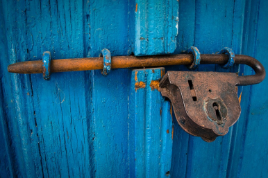 zdjęcie przedstawia metalową kłódkę zamykającą niebieskie drzwi (fot. pixabay)