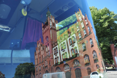 odbicie ratusza miejskiego w szybie autobusu