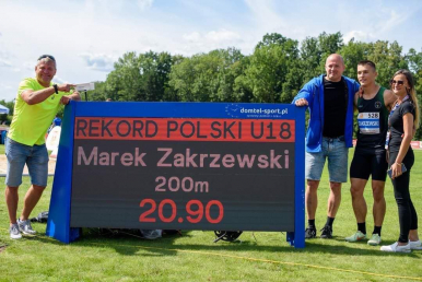 Marek Zakrzewski z rodzicami i trenerem po biegu na 200 m.
