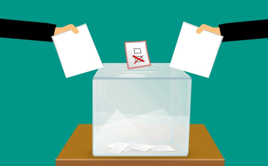 Grafika przedstawiająca urnę wyborczą i dwie ręce wrzucające głosy, także grafikę z kratkami  i skreśleniem jednej kartki