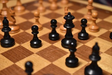 Białe i czarne pionki szachowe na szachownicy.
