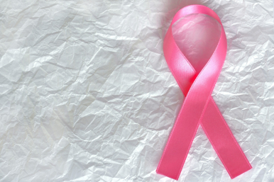 Grafika: różowa wstążka, symbol walki z rakiem piersi, na białym tle