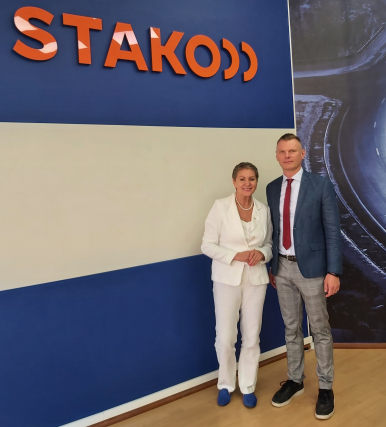Na zdjęciu widzimy dwie osoby - kobietę i mężczyznę, Prezydentkę Miasta Słupska i Dyrektora jednostki biznesowej Stakoo, w tle logo STAKO; oboje się uśmiechają.