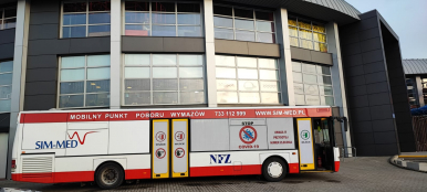 Zdjęcie przedstawia autobus (Mobilny Punkt Poboru Wymazów) stojący pod Parkiem Wodnym "Trzy Fale"
