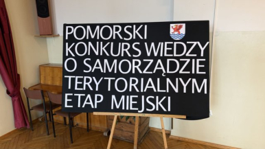 Zdjęcie przedstawia planszę z nazwą konkursu oraz herb Słupska