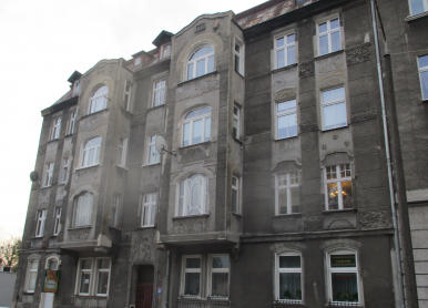 Zdjęcie przedstawia budynek, w którym znajduje się lokal mieszkalny na sprzedaż.