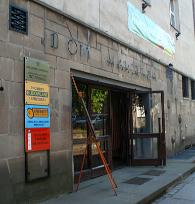 Obraz przedstawia wejście do budynku "Domu Harcerza" w Gdańsku