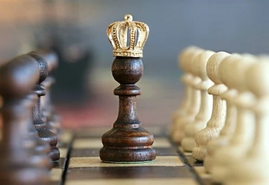 Figurki szachowe z królem na pierwszym planie.