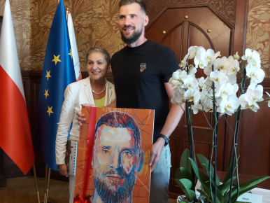 Paweł Leończyk trzyma obraz autorstwa Wojciecha Stefańca, swój portret, wspólnie z Panią Prezydent Słupska