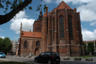 Na zdjęciu widać kościół, samochody i zieleń miejską