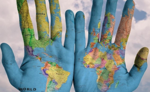 Na zdjęciu mapa świata na otwartych dłoniach