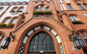 Wejście do budynku ratusza z powiewającymi flagami