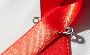 Na zdjęciu czerwona wstążka - symbol solidarności z osobami żyjącymi z HIV i AIDS