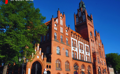 Zdjęcie przedstawia ratusz od strony ulicy Deotymy. W lewym górnym rogu napis SESJA RADY MIEJSKIEJ W SŁUPSKU